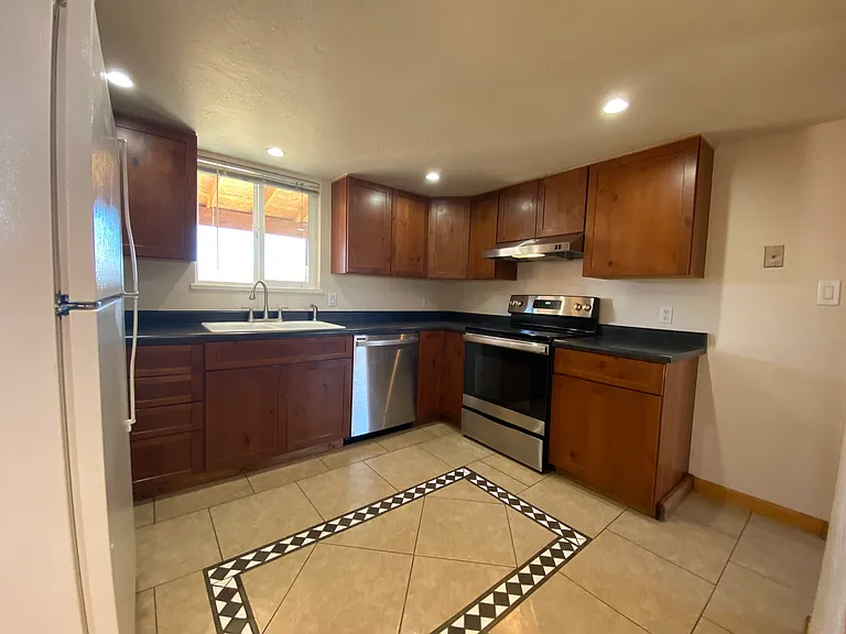 Functional kitchen featuring ample cabinet storage, great workspace, and included appliances for everyday convenience.