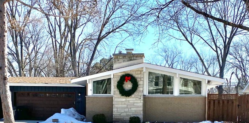 Outside of house has a light brick and navy outdoor paint. Front door with keypad & key option.