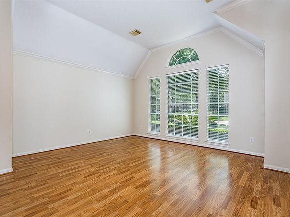 A wall of windows allows natural light to flow into this formal living area! This home boasts extensive crown molding and architectural detailing.