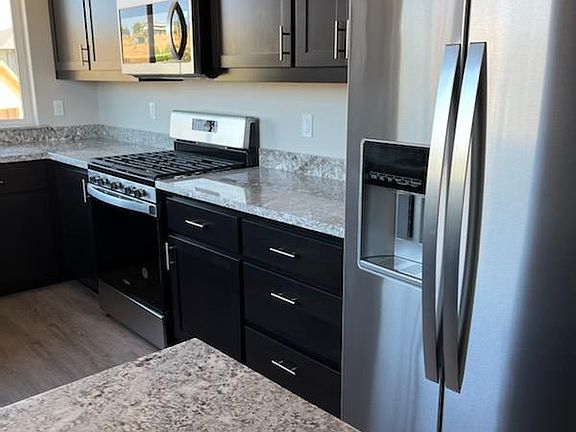 Kitchen has granite countertops and stainless steel appliances.