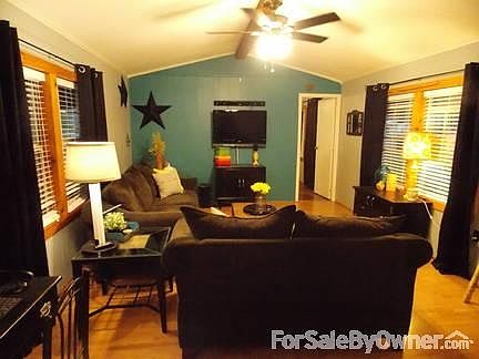 Living Room : Same laminate wood flooring as the kitchen and front door opens into living room