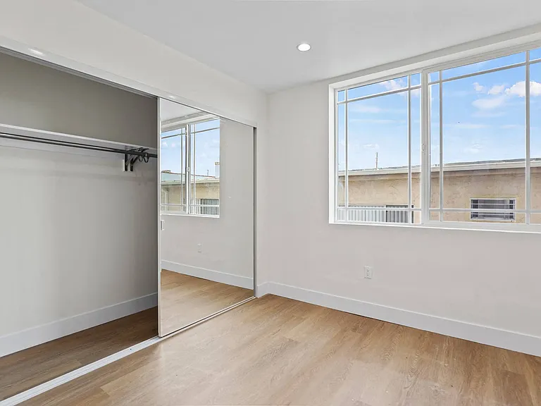 Bedroom with Double Windows, Large-Size Mirrored Closet, Vinyl Flooring, and Recessed Lighting