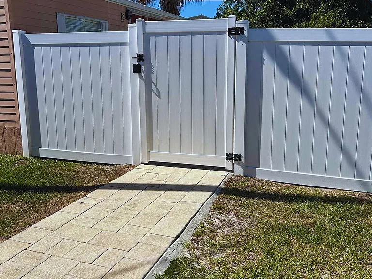 The property features a white fence with a small gate.