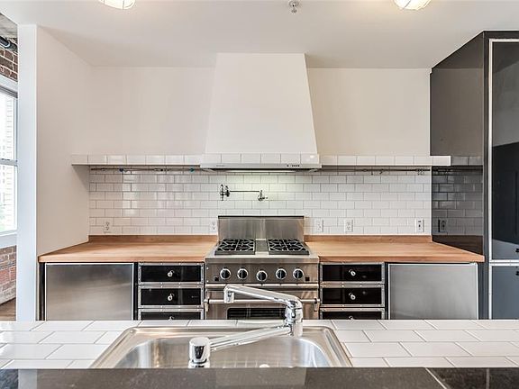 Kitchen is original to 1998 building conversion to residential. The finishes are quite charming and feature Jenn-Aire gas range, separate under counter refrigerator & freezer, and pot filler. It is ready to use or just awaiting your updating to your 