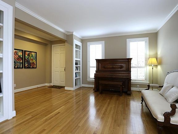 Light and bright formal living room with floor to ceiling windows and built-in book shelves, ample r