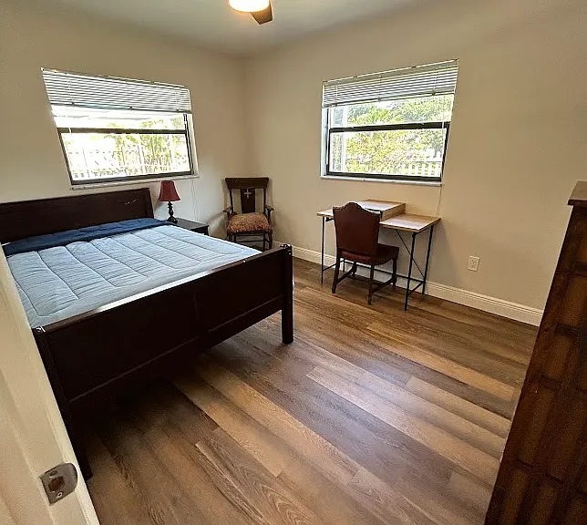 Bedroom 1 - full mattress, desk, chair, side table with lamp, dresser
