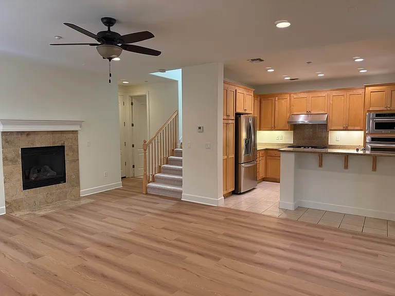 Spacious family room features a gas fireplace, large windows, ceiling fan and a glass patio door that opens to a relaxing private side patio.