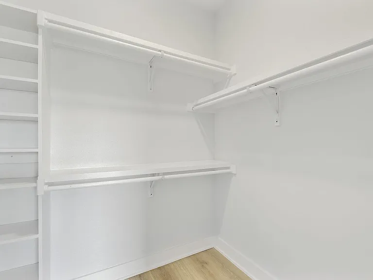 Walk in closet with built in shelving.