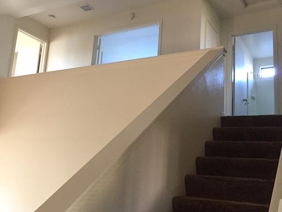 View from entry. stairs and upper level open walkway to master. Double door entry to second bedroom two.