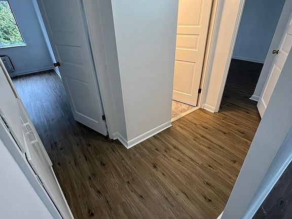 Hallway with built-in storage leading to bedrooms and bathroom