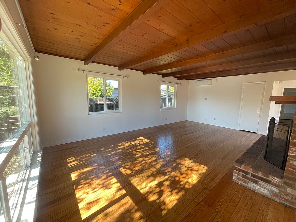 Living room with new windows, new interior paint, freshly refinished hardwood floor & new mini split