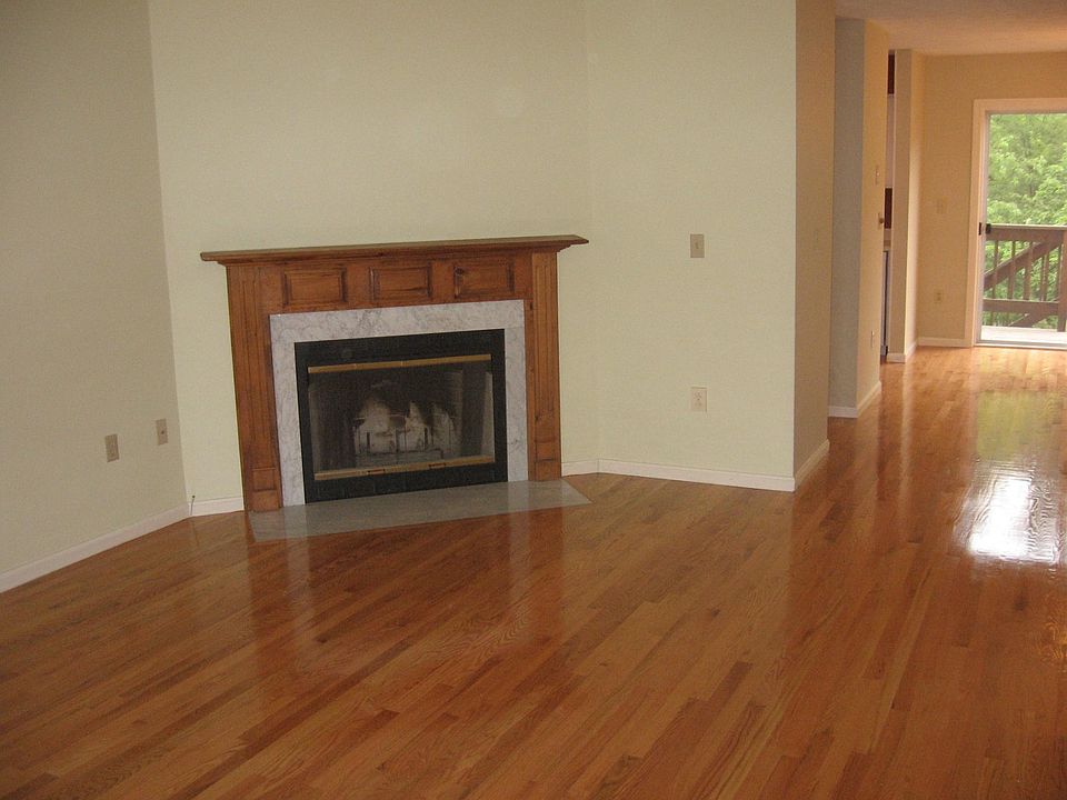 Open concept living room with wood burning fireplace with dining area in the back and slider to deck