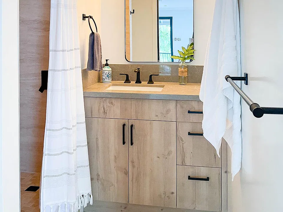 New modern bathroom with travertine floors and shower stall.