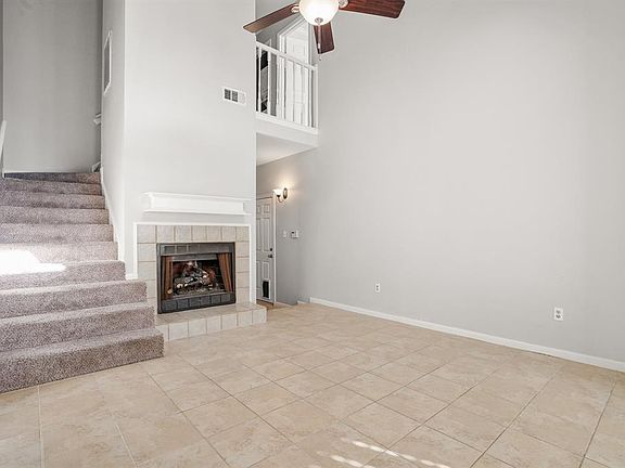 Check out that tile surround gas log fireplace! Neutral tile and neutral paint adorn the main areas of the home. The two bedrooms w/ ensuite baths are located upstairs. The door that is center in the back center of this photo leads to the 1-car attac