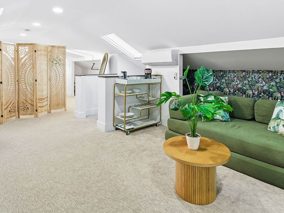 Sunlit living space within the studio with a skylight, featuring a comfortable sofa that converts into a queen pull-out bed_perfect for movie nights and reading.