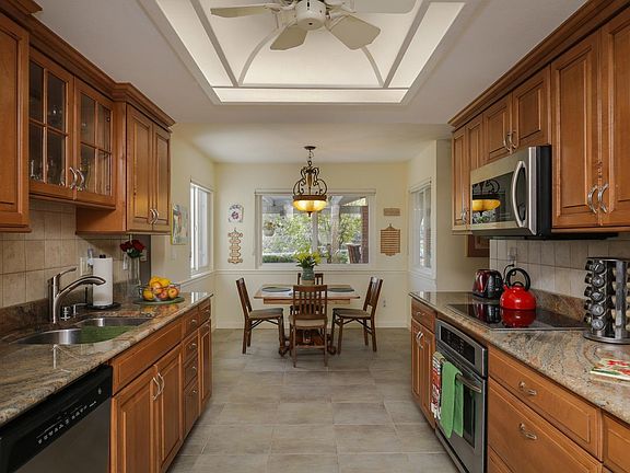 The gourmet kitchen boasts granite counters, raised panel maple cabinets, full tile backsplash, and 