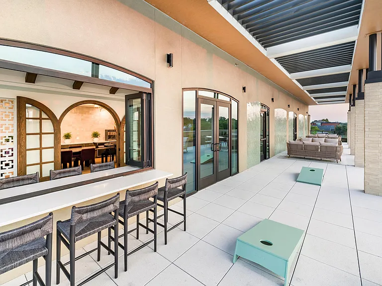 Enjoy Dallas evenings on Modera Trailhead's expansive terrace, complete with lounge seating, bar-style dining, and games for laid-back gatherings.