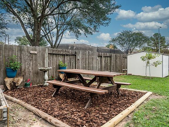 Wooden picnic table and shed included.
