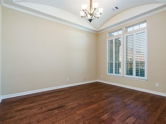 To the right of the entry is the formal dining room highlighted by a beautiful cove ceiling, crown molding, hardwood flooring and plantation shutters.