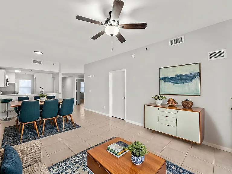 Bright and inviting open-plan living area with modern dining set, elegant decor, and sleek kitchen in a stylish apartment.