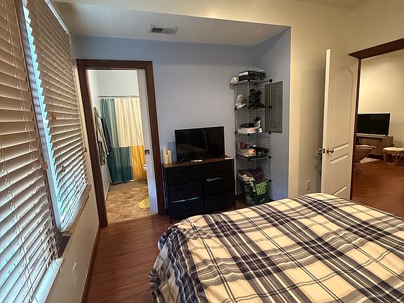 Bright bedroom with additional storage under the bed, a spacious closet, and convenient access to the adjacent bathroom. Perfect for keeping your belongings organized while enjoying easy, private bathroom access.