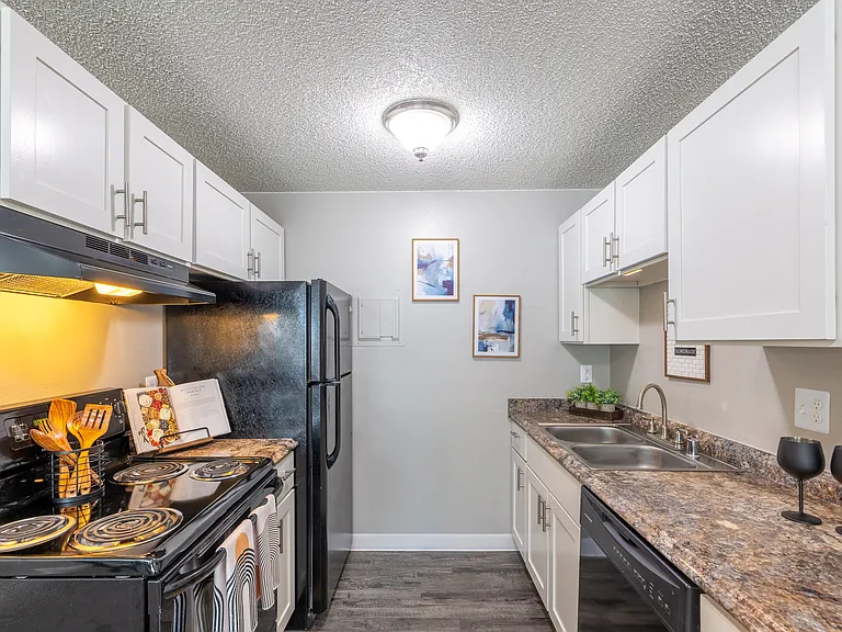 Modern kitchen with sleek appliances, elegant marble countertops, and stylish white cabinetry, ideal for culinary enthusiasts.