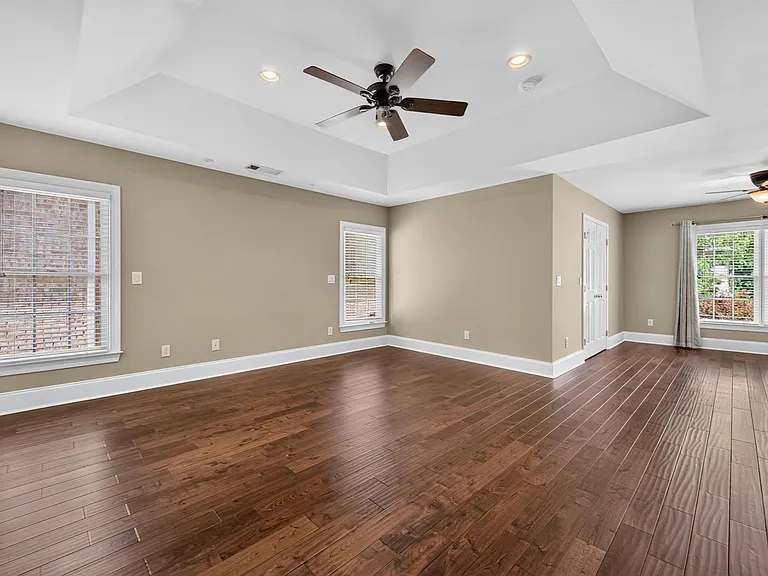 master bedroom - hardwoods, fan, tray ceiling and lots of windows