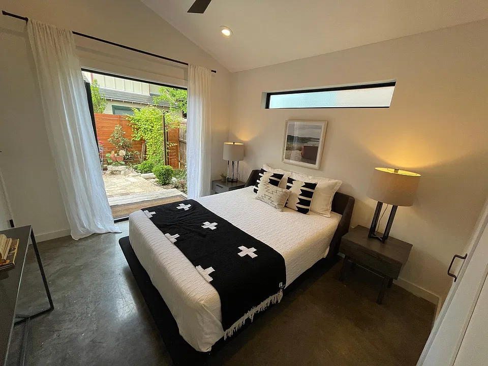 master bed room with double front doors to stone patio