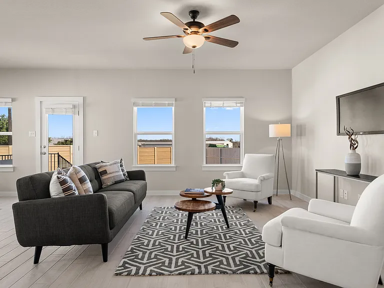 Living area is large with ceiling fan and lots of windows.