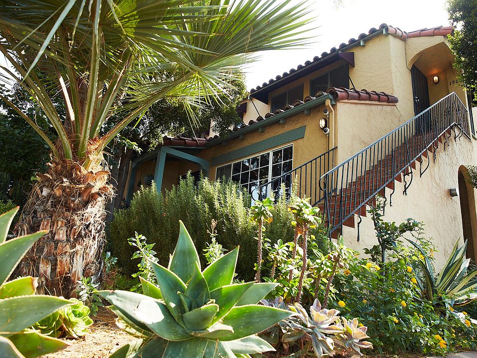 The side view of the Spanish duplex, the stairs leading up to the apartment, and the private entrance.