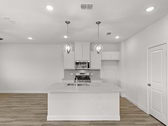 Three-bedroom townhome floor plan by Pacesetter Homes featuring open-concept main-level living, kitc