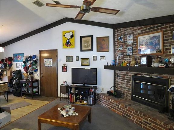 Great room with volume ceiling and wood burning fireplace.