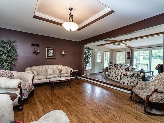 Beautiful sunken living room with a wood burning fireplace, tray ceiling and hardwood floors.