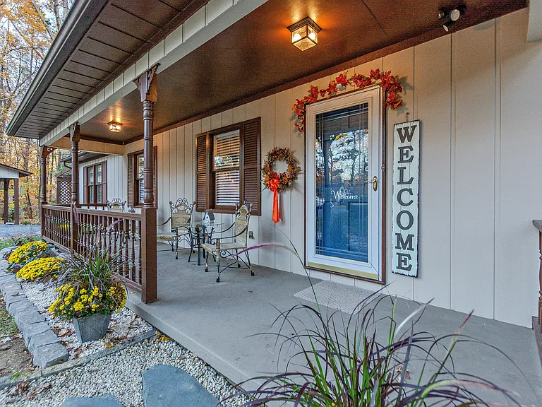 Covered front porch and front entrance. Keyless entry. Chairs and tables for lounging.