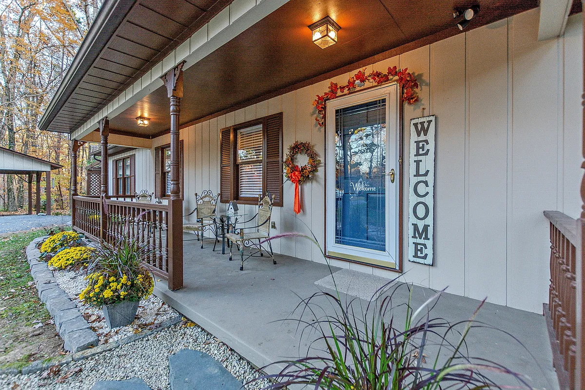 Covered front porch and front entrance. Keyless entry. Chairs and tables for lounging. - 1221 E Mine St