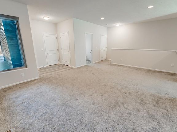 Main Living room with entrances to garage, half bath, staircase to downstairs, and the kitchen