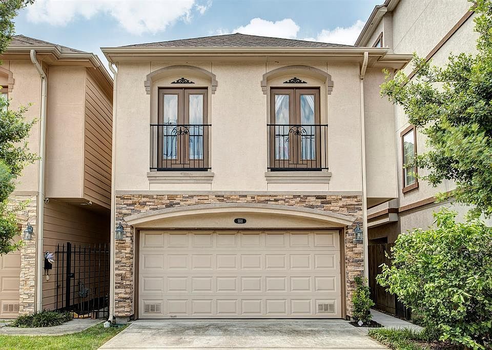 Street view with Juliet balconies from bedrooms. 2 car garage and driveway providing parking for 4 additional vehicles. Includes 2 garage door remotes. Front door located behind personal gate