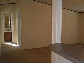 Looking from the kitchen to the living area and hallway with two bedrooms and guest bath.