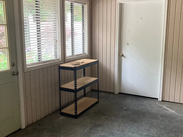 Enclosed back porch with storage room.