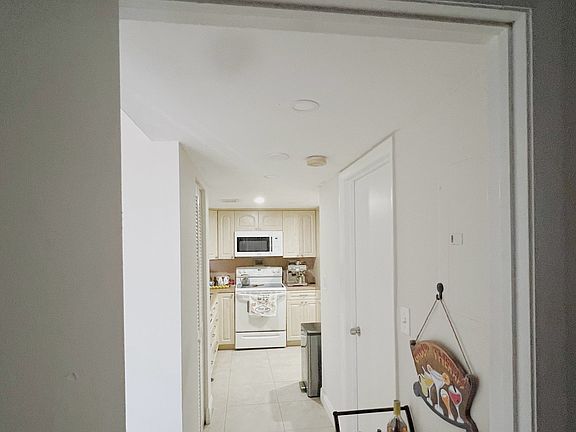This is a picture of the second bedroom. The door on the right leads to the second bathroom, with the pantry directly in front of it and the kitchen beyond.
