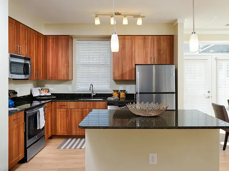 Classic Package I kitchen with stainless steel appliances, oak cabinetry, black granite countertops, and hard surface flooring