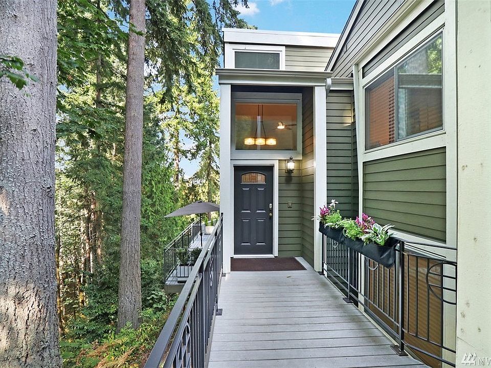 Private entrance with attached 2 car garage with storage nestled among nature.