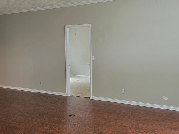 This is the dining and front room with engineered hardwood floors. Beautiful space for a table and extra living area. The door leads to the primary bedroom.