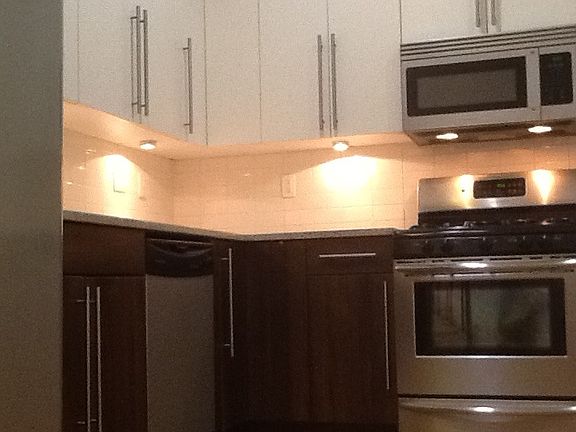 A modern kitchen design with task lighting and subway tile b