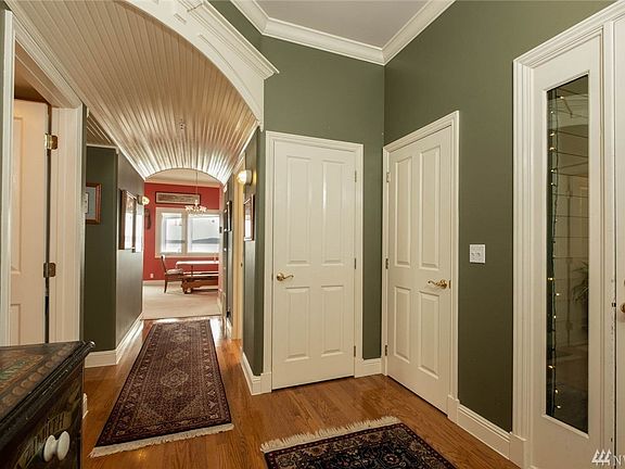 Handsome front door with window lights welcomes you into this one of a kind waterfront property. Enty leads down the hall (notice arched wainscoting hallway) to second bedroom on the left, full guest bath to the right, dining/living in background. Master bed is behind the camera. 