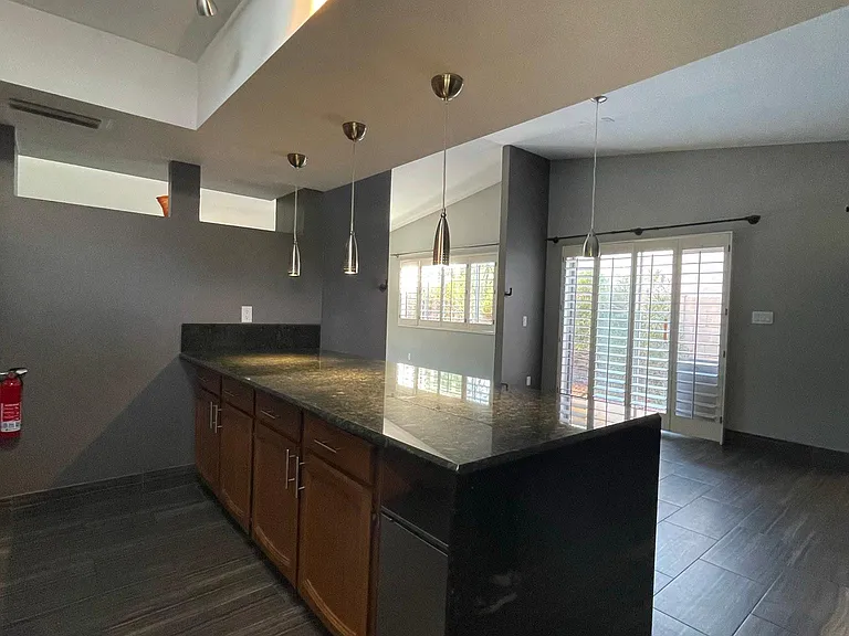 Kitchen with granite counter tops and a peninsula with waterfall effect.
