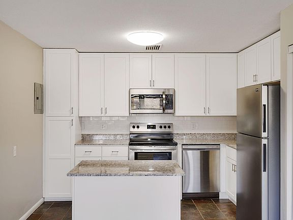 Fully updated kitchen includes granite counters, stainless appliances, subway tiled backsplash, floating island and full height upper cabinets.