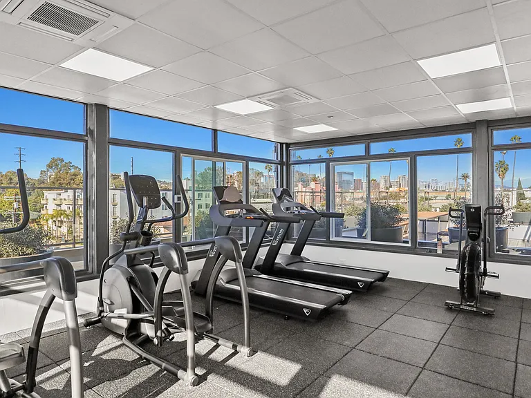 Fitness Center Including Treadmills, Ellipticals, Stationary Bikes, and Rooftop Views of the City