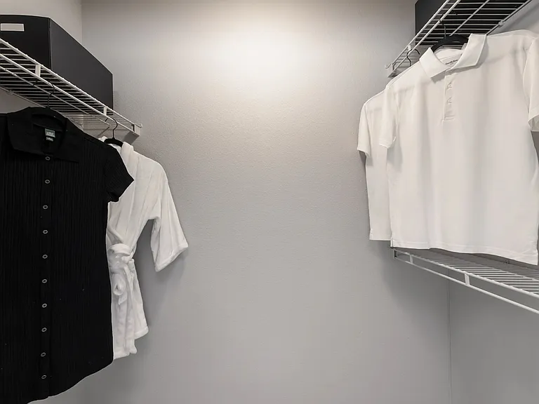 This spacious walk-in closet offers ample storage and organization options, perfect for keeping your wardrobe neat and accessible.