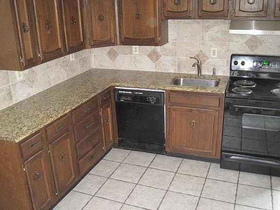 Eat-in gourmet kitchen with tiled backsplash and granite cou